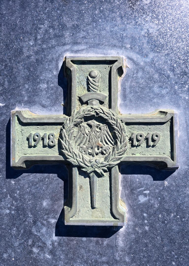 Krzyż Powstańców Wielkopolskich z datami 1918 i 1919 oraz godłem Polski pośrodku, symbol powstania wielkopolskiego.